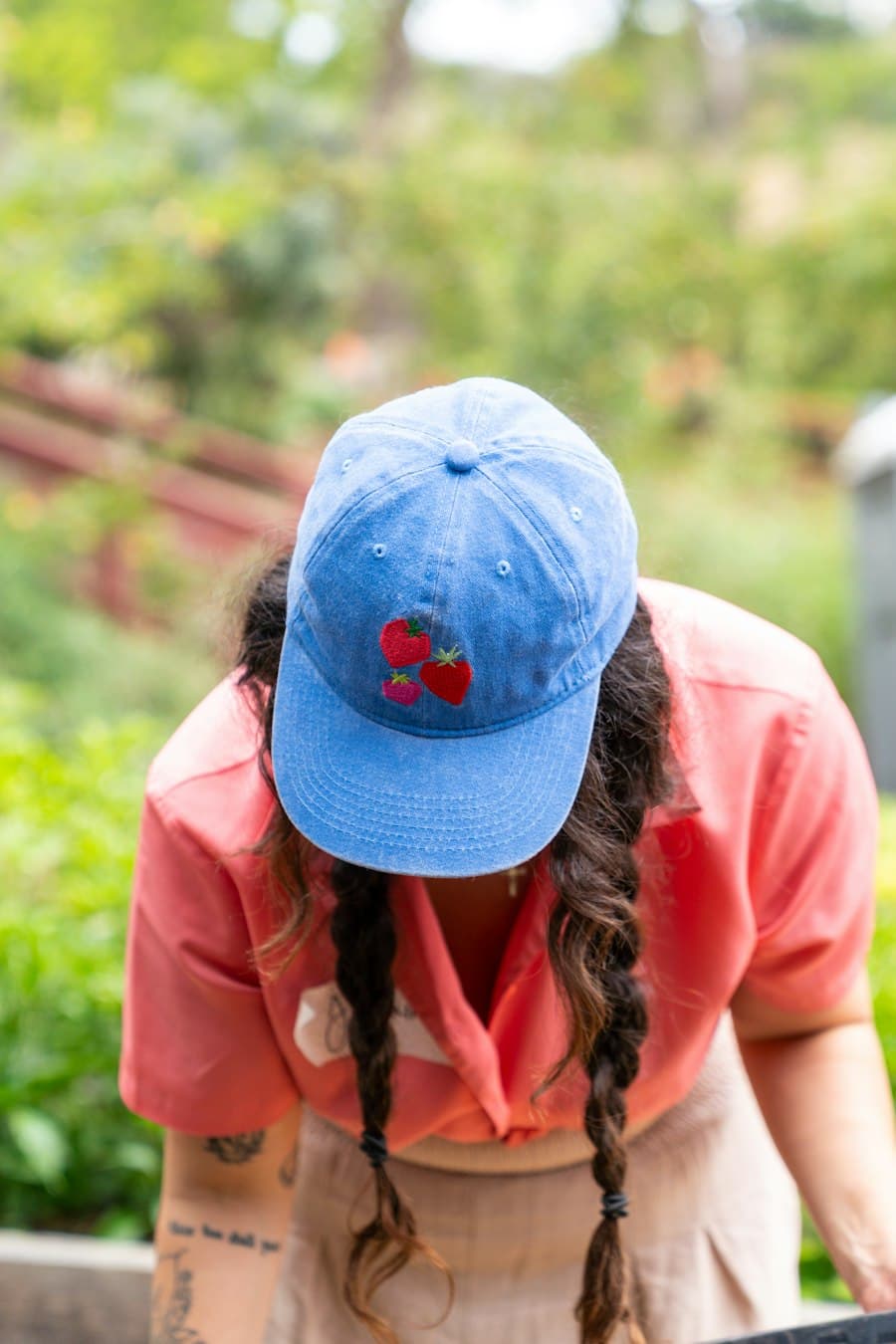 A volunteer in a cap working in a community garden