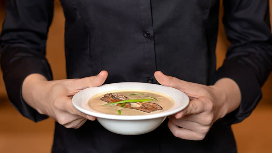 Hands holding a bowl of hot soup